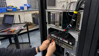 Automated test rack acceptance check with probes, labeled cables, and rack instruments